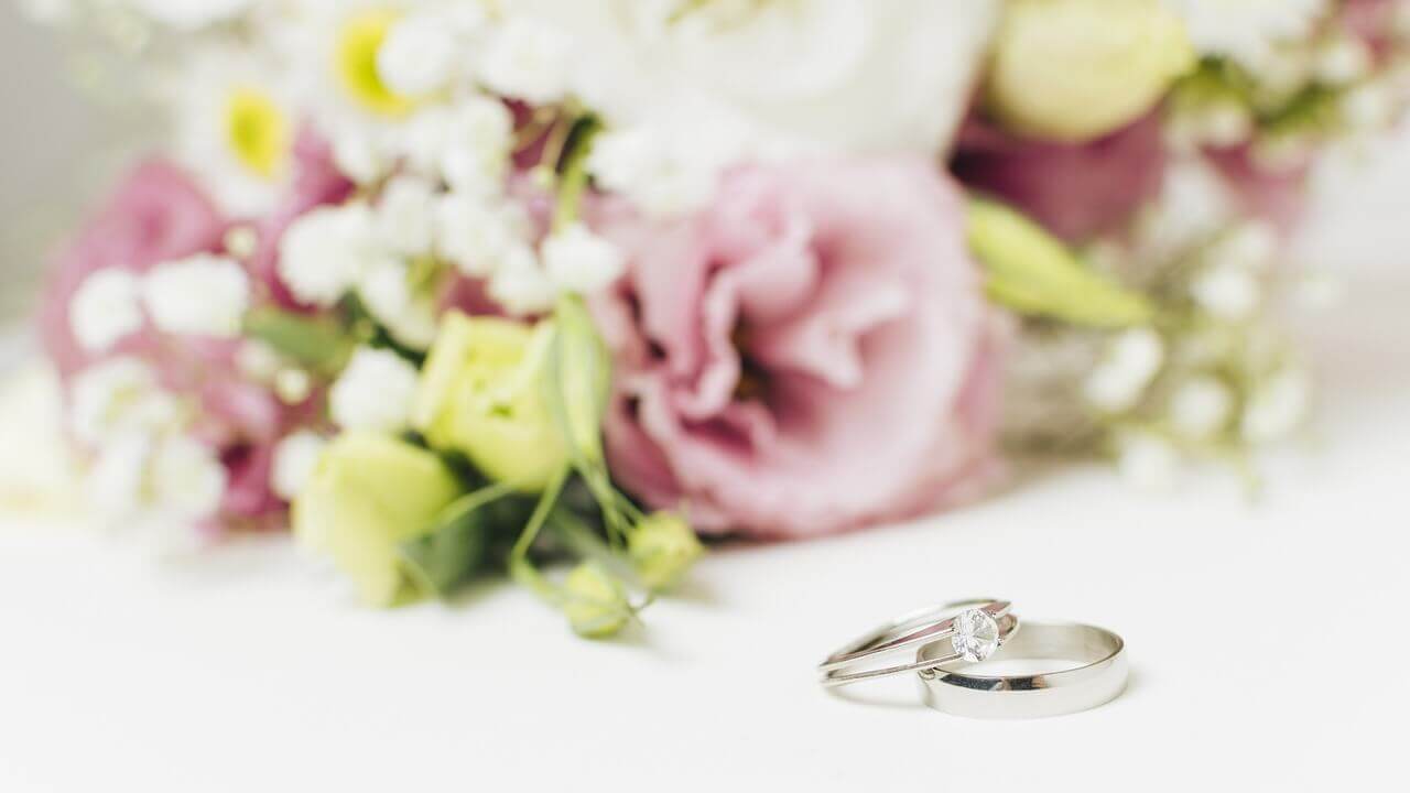 花束の前に置かれた婚約指輪と結婚指輪